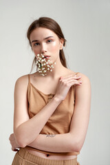 Gentle natural portrait of a young girl with a gypsophila sprig. Portrait in natural colors.
