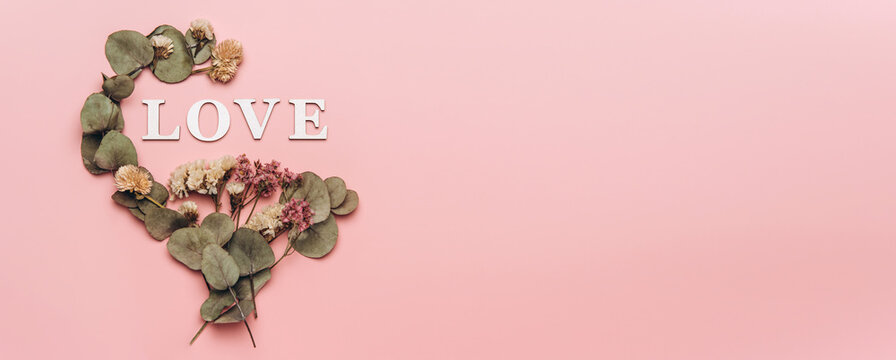 Creative flat lay of word love on soft color  background with natural plants