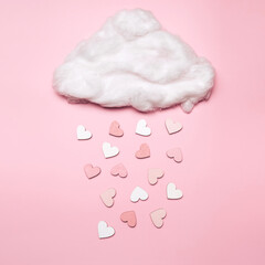 Creative flat lay of heart shape objects falling from the cloud on pastel background. Love concept