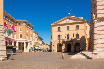 Fototapeta na wymiar The historic Piazza Dante in central Grosseto in Tuscany, looking down Corso Giosue Carducci on the left. On the right is the Romanesque Cattedrale di San Lorenzo, Saint Lawrence Cathedral.