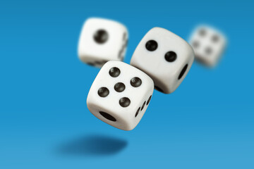  White playing dice cubes in motion on the blue surface, selective focus