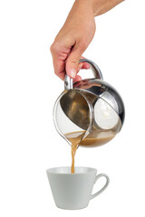 Hand holding a transparent pot and pouring coffee with cream in the white porcelain glass, isolated on a white background