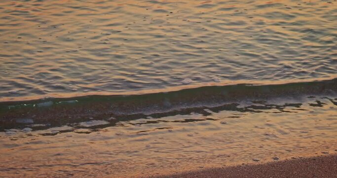 Beautiful sunset seascape at Azov sea with awesome sun golden reflection on calm waves, pan shot