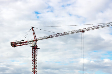 High crane for house building at construction site on blue sky background.