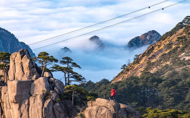 View of the cable car and photographer from the view point of the top of Huangshan Mountain or Yellow mountain in the winter season and a lot of the snow.For traveler go to the top of mountain.
