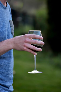 Feiern im Freien ein junger Mann hält in der Hand ein Glas Rotwein