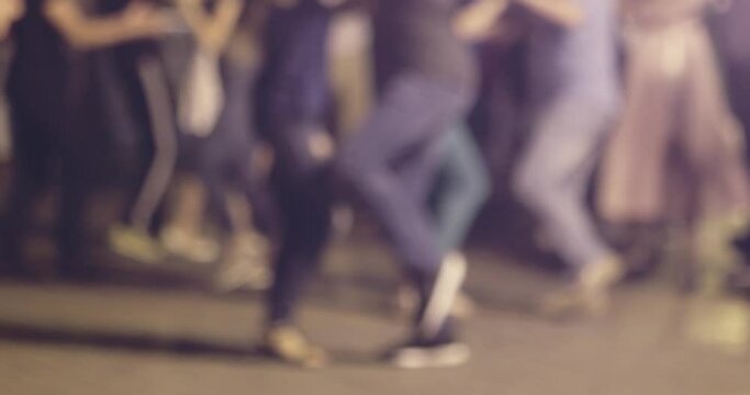 Defocused group of young people couples dancing social-dancs in the night street, copy-space on foreground. Defocused group of young people dancing salsa in the night street, copy-space on foreground.