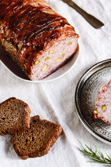 Terrine. Meatloaf. Traditional French cuisine loaf of meat, similar to a pâté, with bacon and pistachios. Selective focus