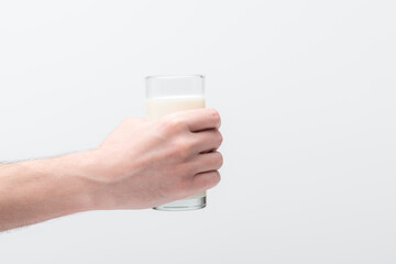 Man with naked hairy hand holding glass of milk