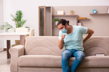 Obraz premium Young man coughing at home during pandemic