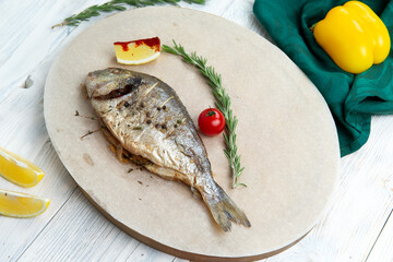 Cooked dorado fish in a plate.