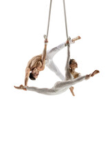 Thoughtful. Couple of acrobats, circus athletes isolated on white studio background. Training perfect balanced in flight, rhythmic gymnastics artists practicing with equipment. Grace in performance.