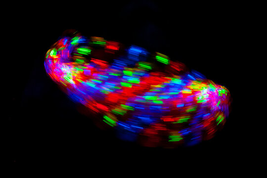 Moving circular lights and parabolas, blurred, on black background. (Luzes coloridas borradas, em forma circulares e par&aacute;bolas)
