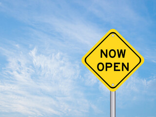 Yellow transportation sign with word now open on blue sky background
