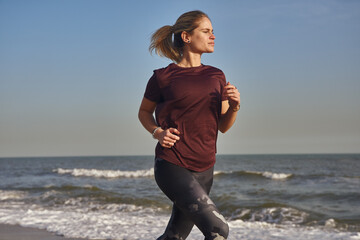 Blonde woman with a pony tail running on the beach