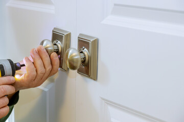 Naklejka premium Worker installing a new dummy lock in house on door