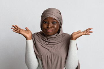 I Don't Know. Doubtful Black Muslim Lady Shrugging Shoulders And Spreading Arms - obrazy, fototapety, plakaty