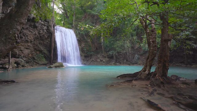 waterfall clear emerald water and blue pool or pond on summer with rock and tree for holiday relax travel in green jungle or forest at erawan waterfall floor 3 for nature landscape background on 4K