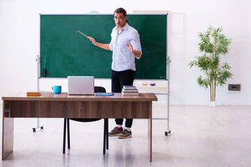 Young male teacher in front of blackboard © Elnur