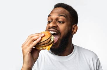Portrait Of Hungry Black Man Eating Burger Over White Background