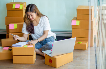 Portrait of Starting small businesses SME owners female entrepreneurs working, box and check online orders to prepare to pack the boxes, sell to customers, sme business ideas online.
