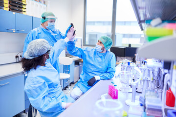Forscher Team gibt High Five nach Erfolg im Labor