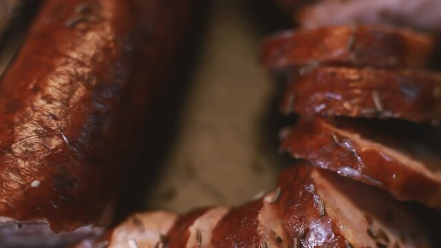 Sprinkle cumin on sliced sausage and bread. The tray rotates. Selective focus