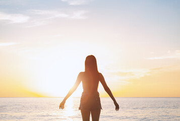 Silhouette sexy woman with hands on summer sunset beach. Christian praise on Easter good friday...