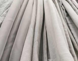Obraz premium Detailed close up view on samples of cloth and fabrics in different colors found at a fabrics market. selective focus,