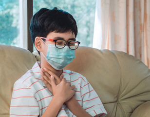 Little ill boy get sore throat or choking can't breath with unhappy and wearing face mask to...
