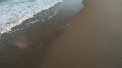 Clear sea water, wave and sand beach. Text space.