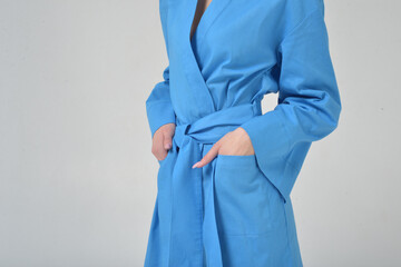 Girl without a face in a blue robe on a white background in the studio