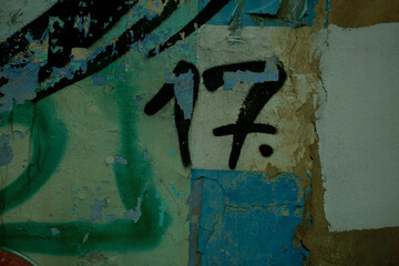 Number 17 in spray painted graffiti detail on an old grungy wall with damaged paint in a full frame view