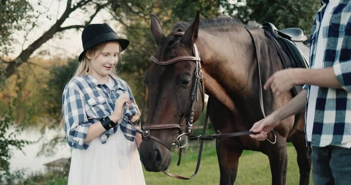 Funny girl at a photo shoot with a horse. Green tourism on the ranch