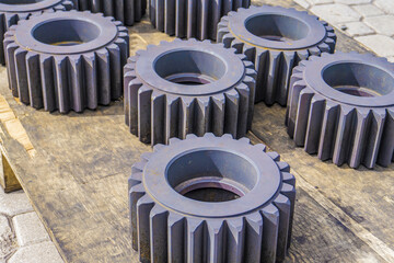 Heat-treated gears on a wooden rack, cool down after quenching in an oven. Gear cutting production...