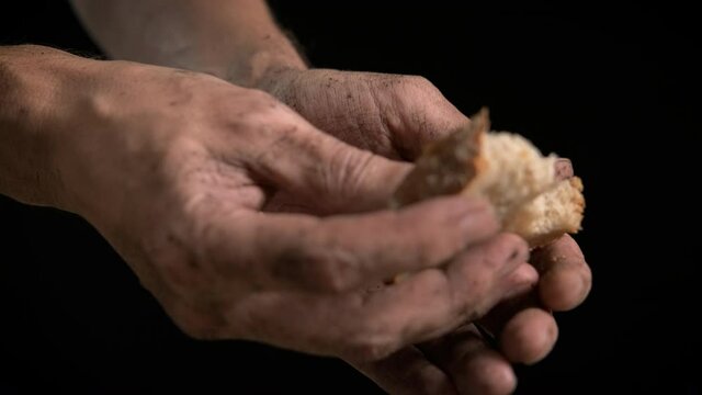 Hunger. Homeless man's hands with a piece of bread.