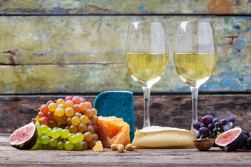 Various types of cheese with grapes and figs