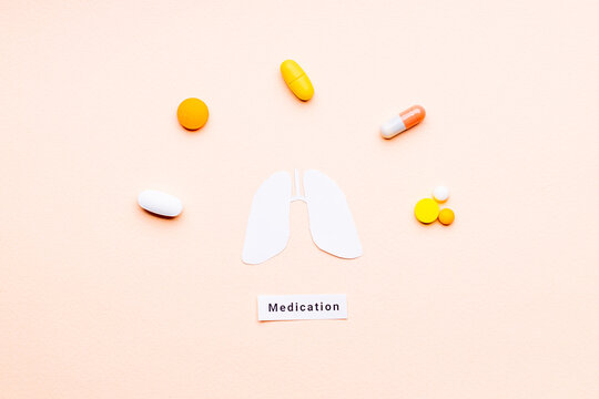 lung medication concept. multiple drugs and pills near lungs symbol over pink background. outer space