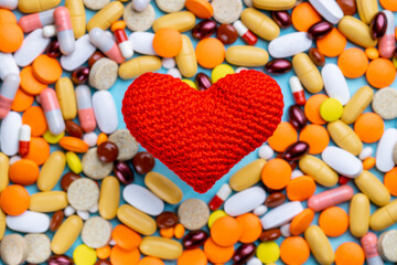 heart cardio symbol over assorted pills background. cardio concept. above view