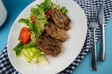 Meat with vegetables. Pork medallions. Grilled meat. Cutlets close-up. Beef.