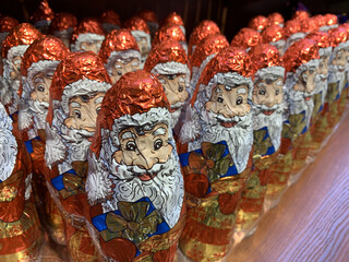 Candy in the form of Santa Claus. Christmas sweets on a supermarket shelf. Many bright toys: Santa Claus.