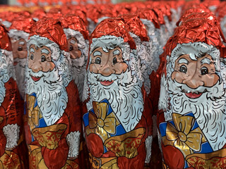 Candy in the form of Santa Claus. Christmas sweets on a supermarket shelf. Many bright toys: Santa Claus.