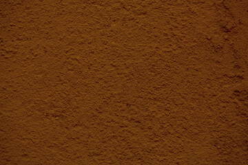 Background texture of a rough finish concrete wall painted in a red brown color in a full frame view