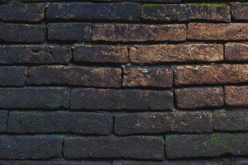 The texture of old wall which is black and orange bricks