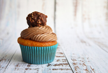 cupcake con chocolate en un fondo de madera - 403056360
