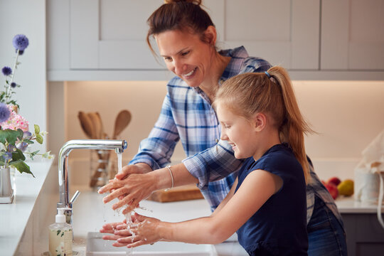 Mother And Daughter Washing Hands With Soap At Home To Stop Spread Of Infection In Health Pandemic