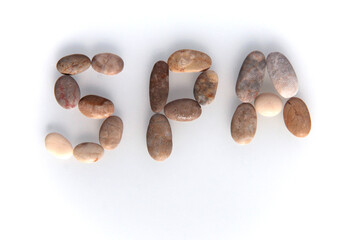 Pebbles on white background, sea pebble. Inscription, text, word: SPA. Concept
