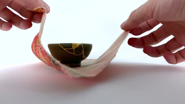 Artisan working on kintsugi process. Slow motion cinematic Kintsukuroi video. Preparing the pottery phase.
