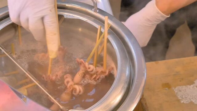 A food in stick dipped on a hot water in Tokyo Japan found inside the Tsukiji fish market
