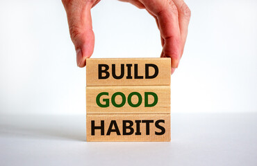 Build good habits symbol. Wooden blocks with words 'build good habits'. Male hand. Beautiful white background, copy space. Business, psychological and build good habits concept.